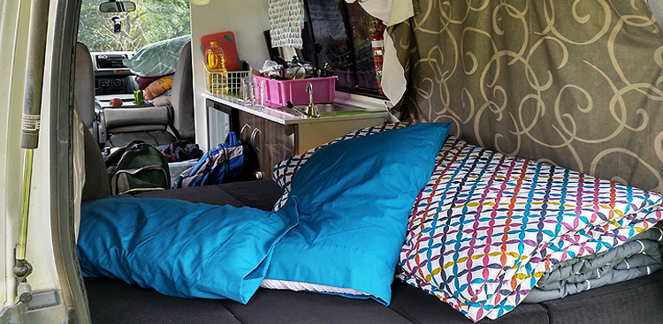 Schlafbereich mit bezogenem Doppelbett im Trustee Traveller von Chilli Rentals Neuseeland