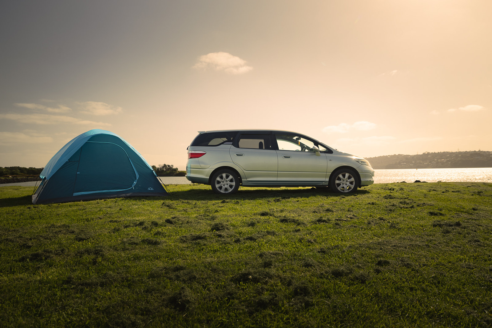 Budget Camper mit aufgebautem Zelt im Abendlicht