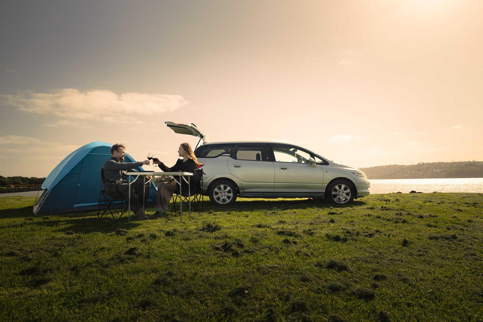 Campingplatz mit Tisch und Stühlen neben dem Budget Camper