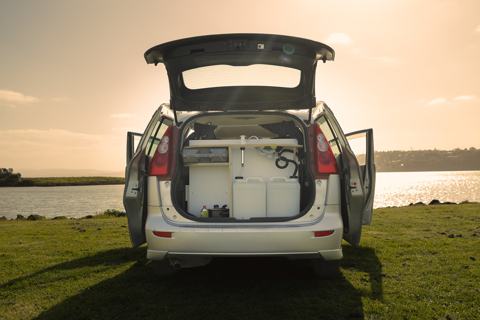 Medium Budget Camper mit geöffneter Heckklappe am Wasser